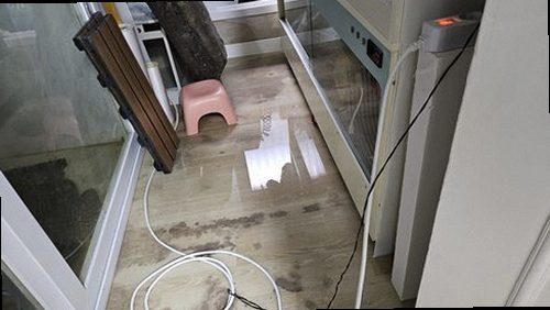 부산 누수탐지 누수 원인 확인을 위해 베란다 배수구와 접합부를 점검하는 모습
